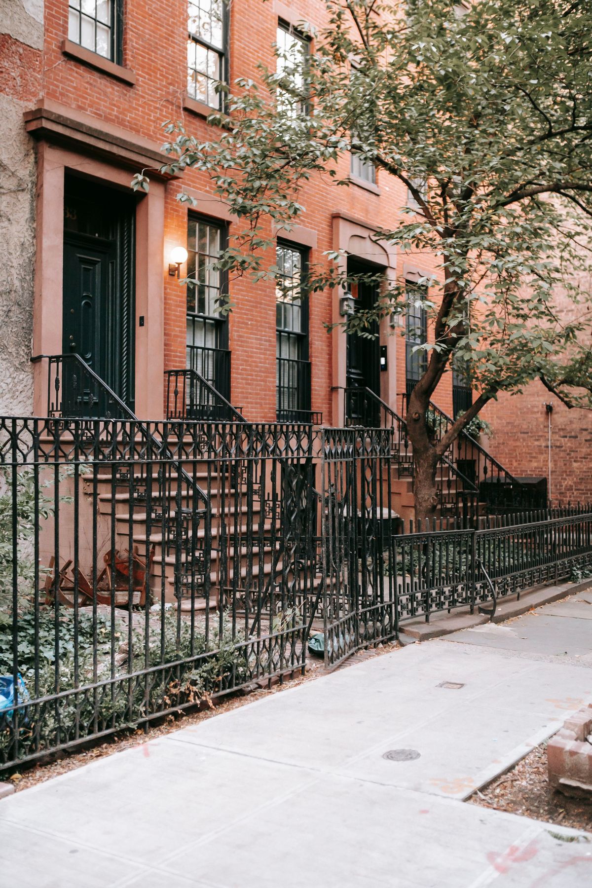 Brownstone homes with iron railings on a Brooklyn style street