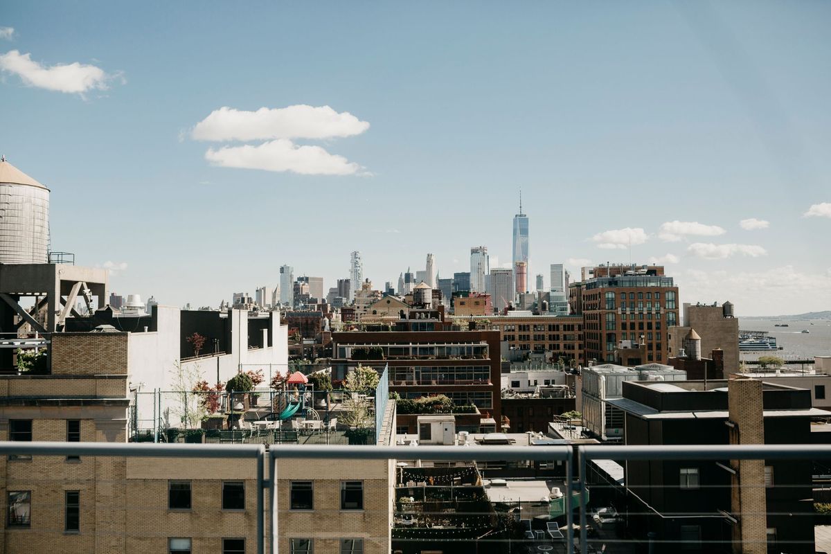 Flat rooftops of New York City buildings with the skyline in the distance